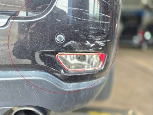 Detailaufnahme: Anbauteile rechts gebrochen / PDC angestoßen Schadengutachten nach Unfall auf Parkplatz.