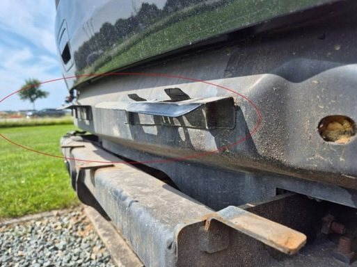 Detailaufnahme: Heckblech / Stoßfängeraufnahme deformiert Schadengutachten nach Unfall auf Parkplatz.